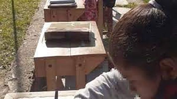 Niños dan clases en el patio, pese a tener una moderna escuela totalmente terminada