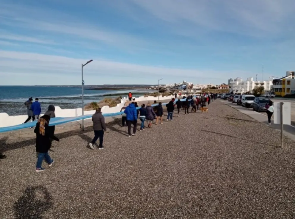 Cientos de grutenses llevaron una bandera argentina al mar y pidieron la municipalización